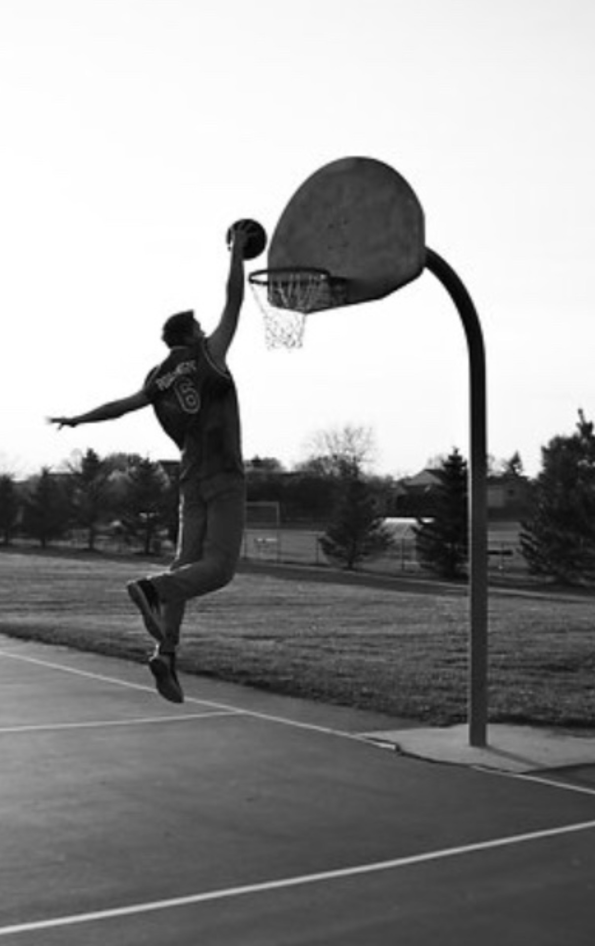 Joshua Friesen rising for a dunk on an outdoor court
